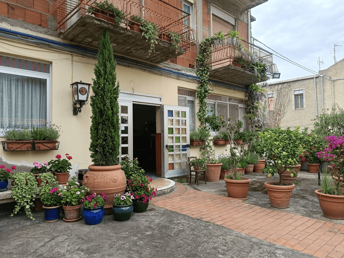 Giardino con piante e fiori in vasi di terracotta e ceramica davanti a un locale commerciale in vendita a Pace del Mela.