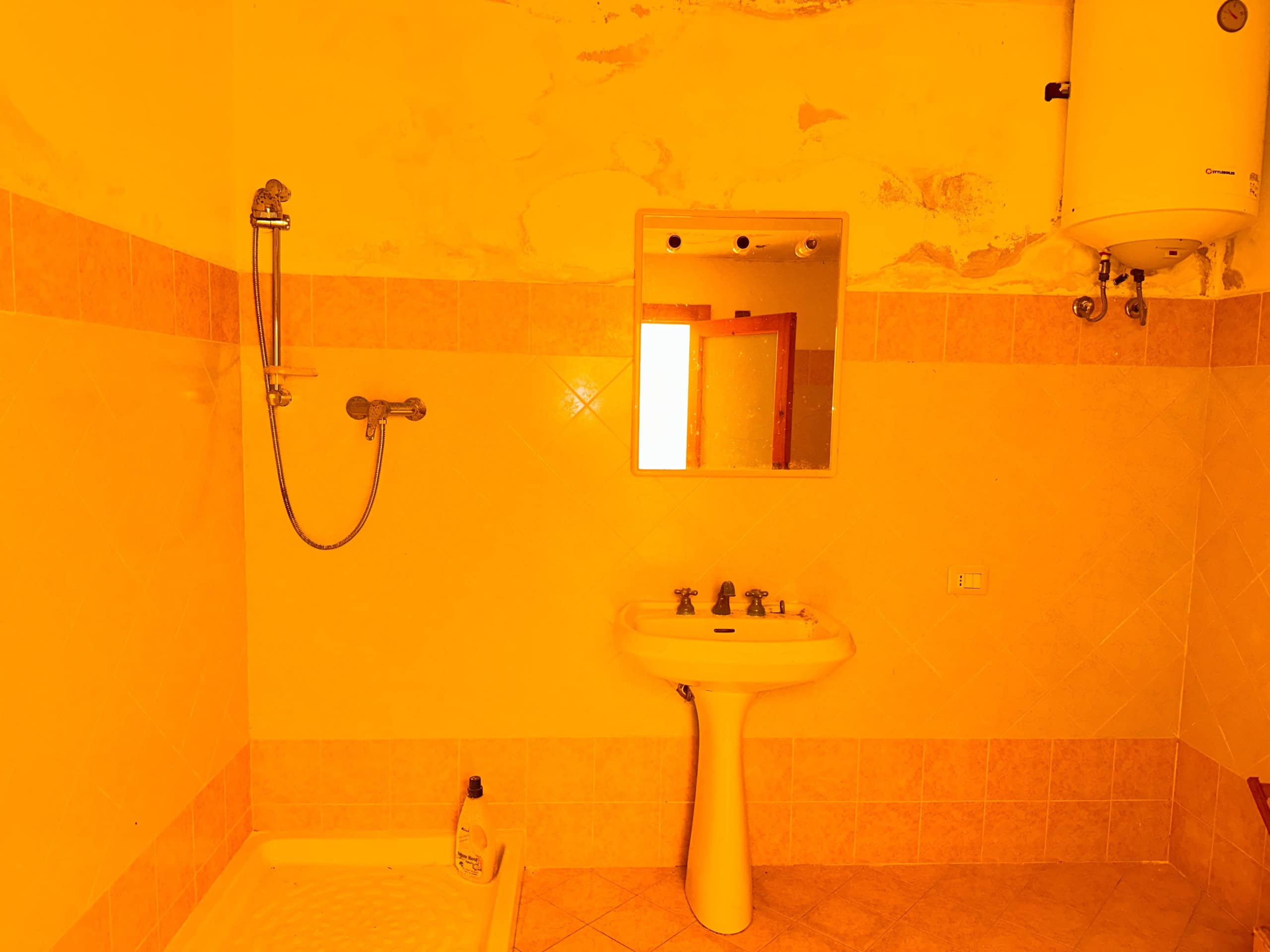 Bagno in una casa indipendente in vendita a Milazzo, con lavabo, specchio e doccia.