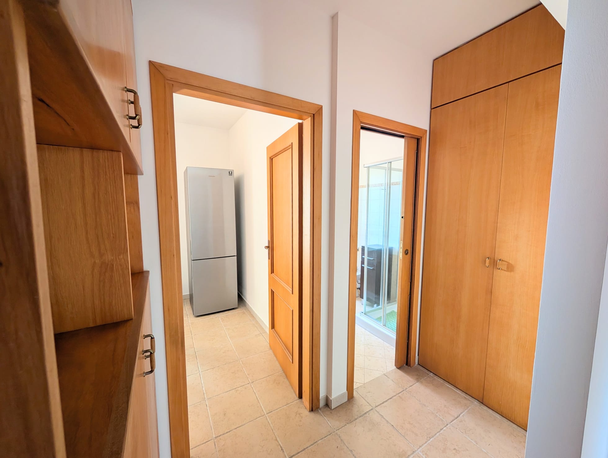 Interno di una villetta a schiera con armadi in legno e accesso a balcone.
