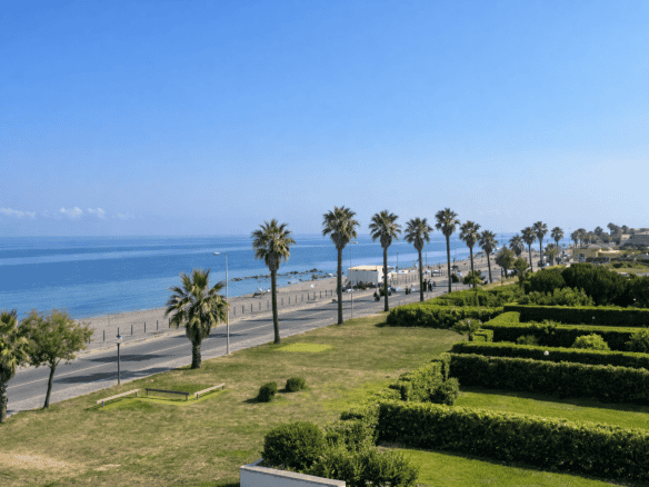 Panorama di Capo d'Orlando con spiaggia, palme e mare, ideale per immobili in vendita in zona.