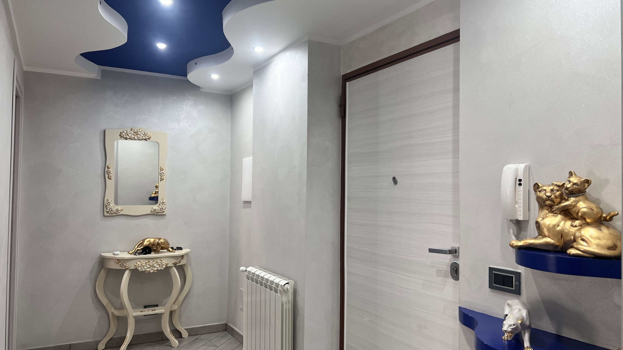 Ingresso moderno e raffinato dell'appartamento in vendita in Via Adolfo Celi 50, Messina, con decorazioni di lusso e dettagli di design.
