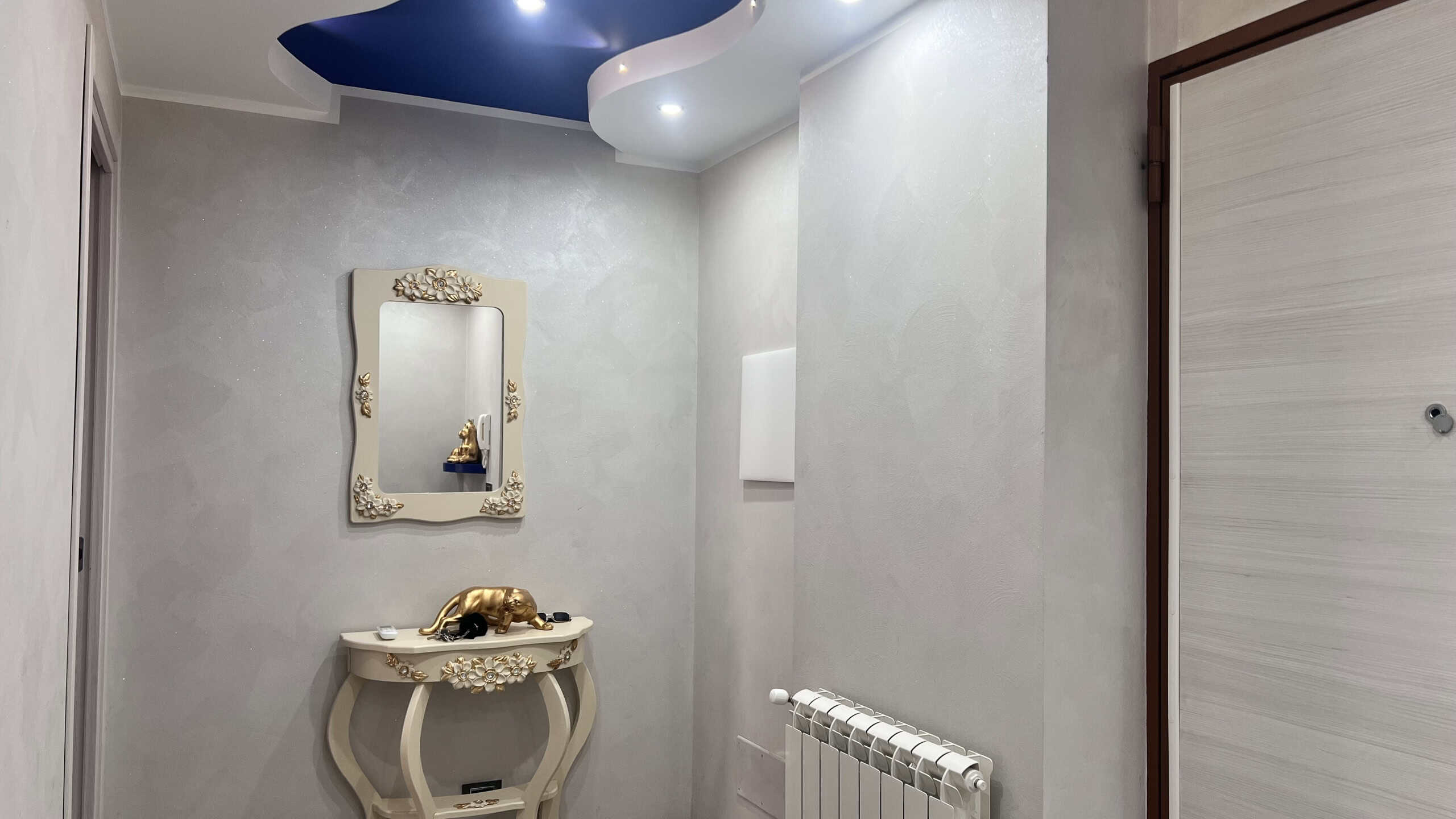 Vista dell'ingresso di un appartamento in vendita in Via Adolfo Celi 50, Messina, con porta moderna e decorazioni eleganti.
