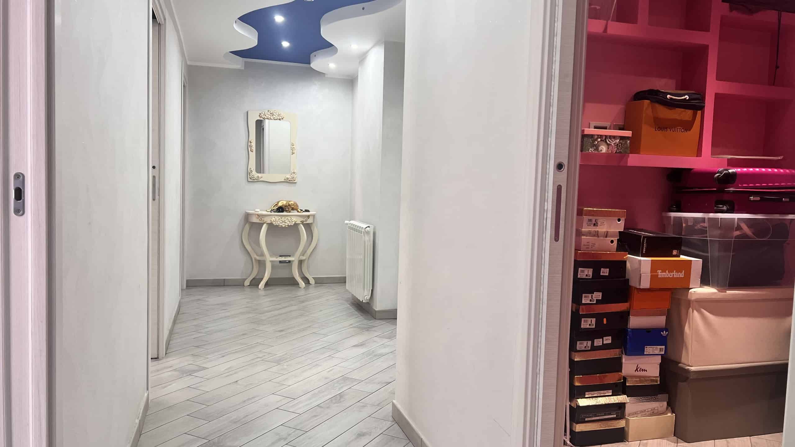 Ingresso spazioso e luminoso dell'appartamento in vendita a Messina, con pareti bianche, pavimento in piastrelle chiare e decorazioni moderne.