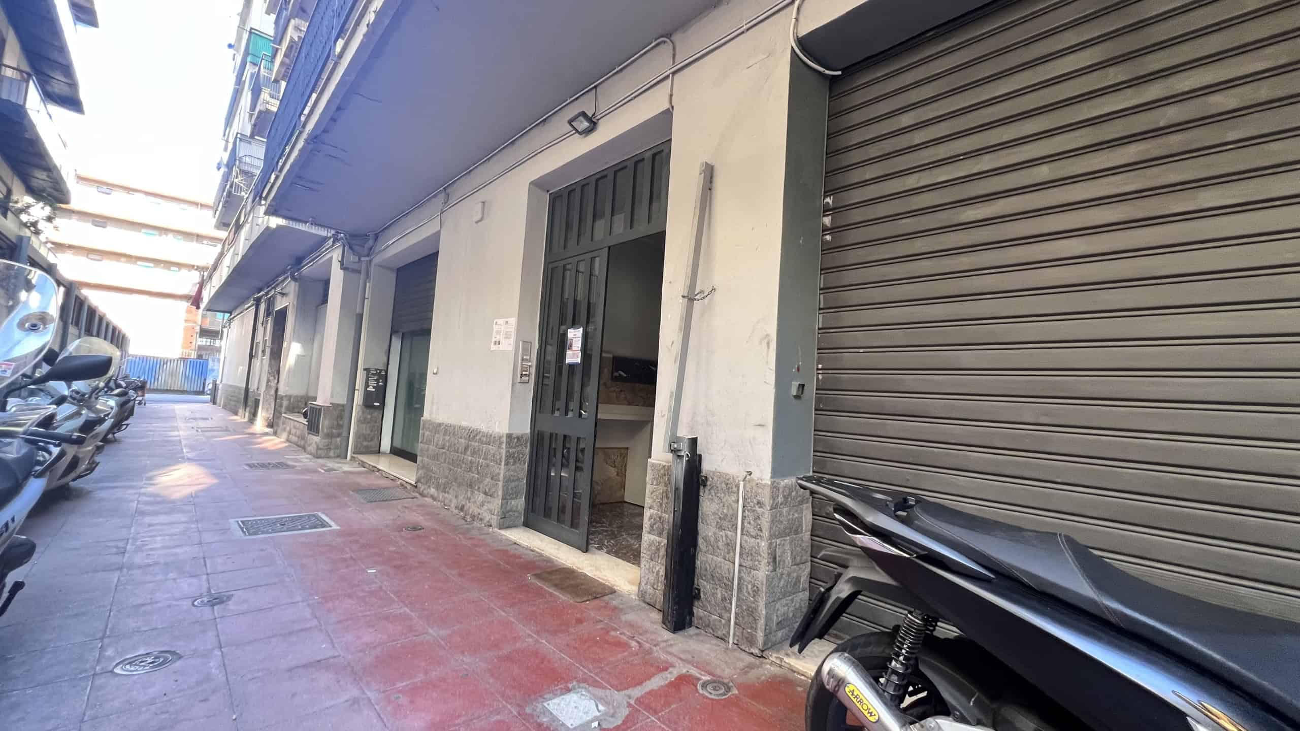 Vicolo di strada con negozi chiusi e parcheggio, in zona centrale di Messina, vicino a Via Adolfo Celi 50.