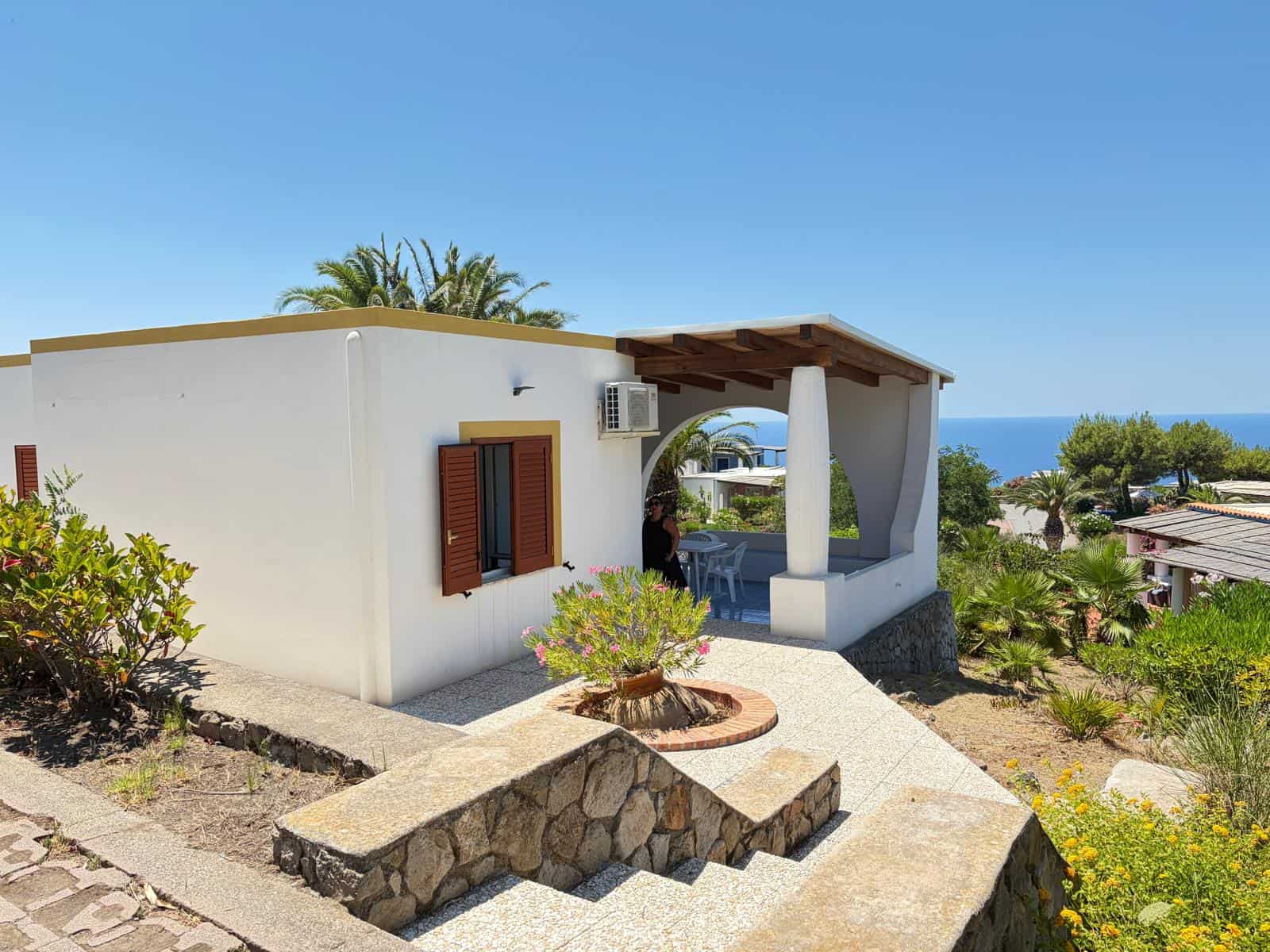 Casa al mare con veranda coperta, giardino e vista sull'oceano, in un ambiente soleggiato e tranquillo, ideale per vacanze rilassanti.