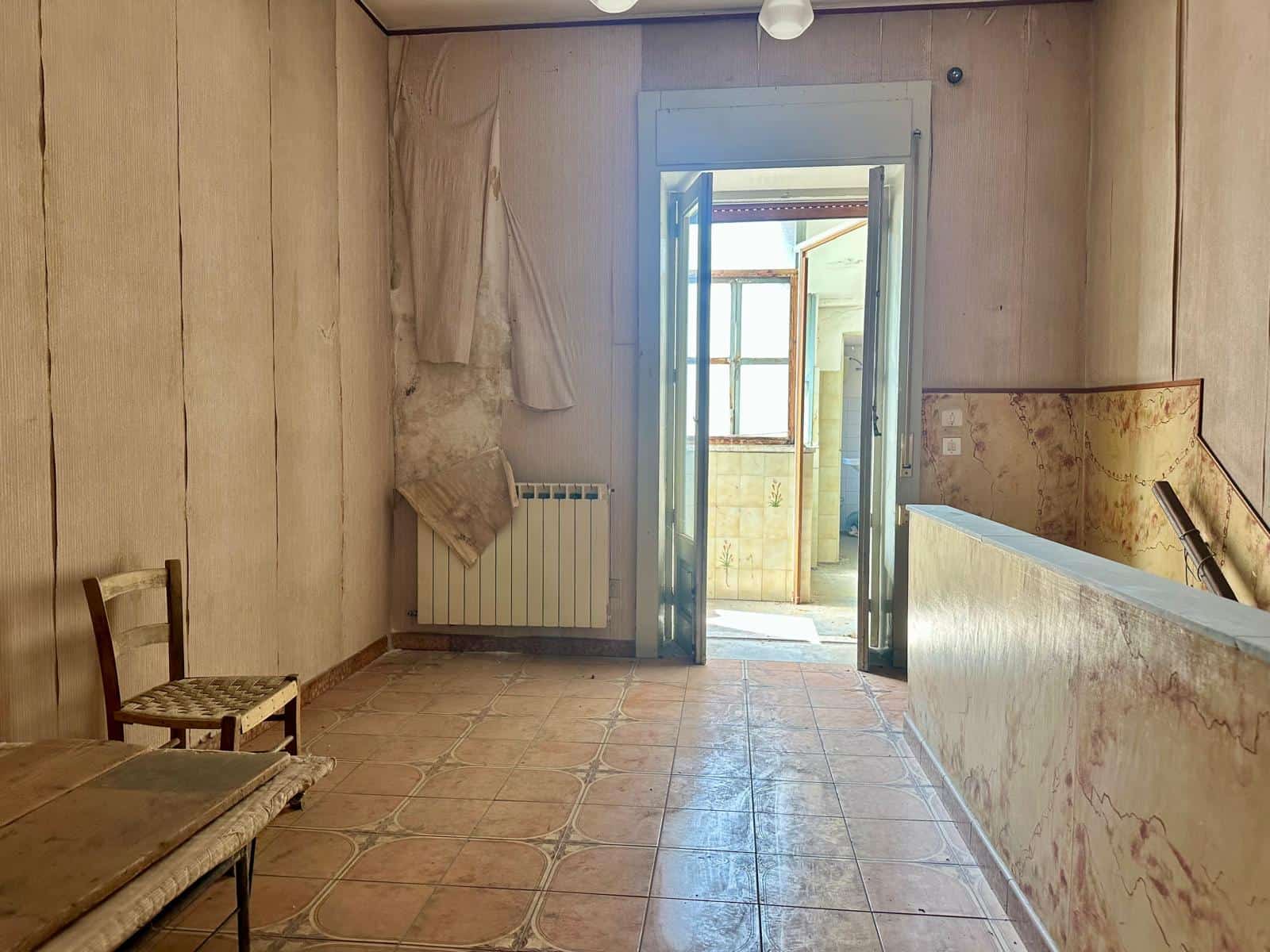 Interno di una casa indipendente in vendita a Barcellona P.G., vista su balcone e pareti in legno.