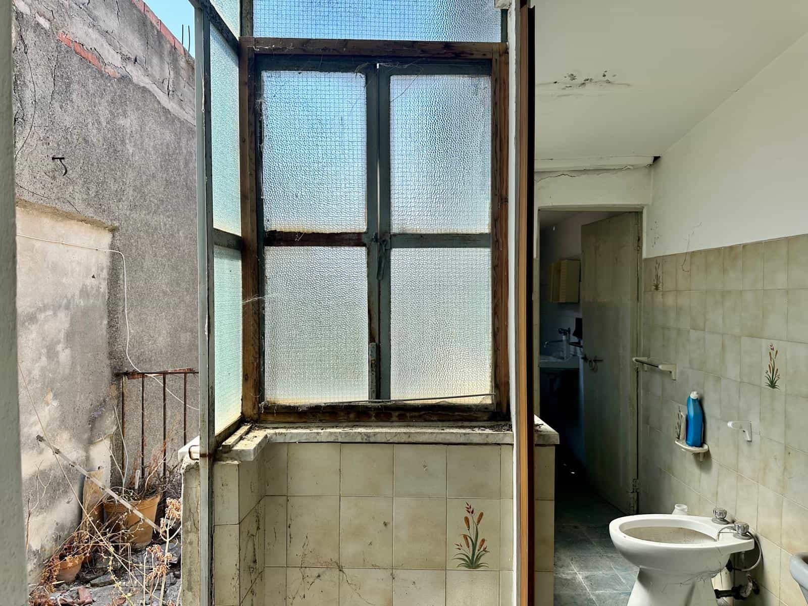 Finestra vecchia in bagno di una casa in vendita a Barcellona P.G.