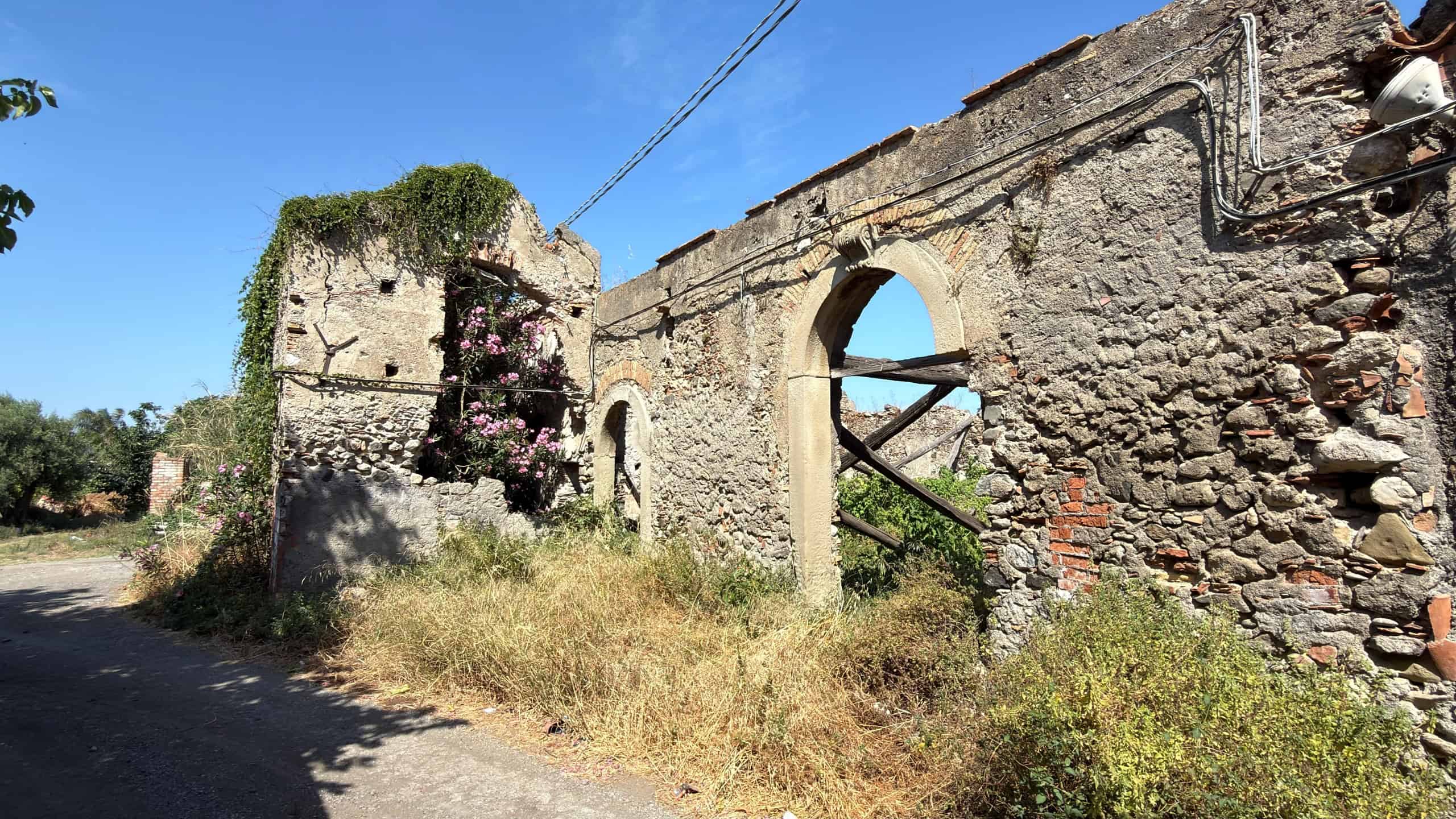 WhatsApp Image 2026-07-01 at 16.48.15 Resti di un edificio storico in pietra con archi e vegetazione, scenario rurale in Italia.