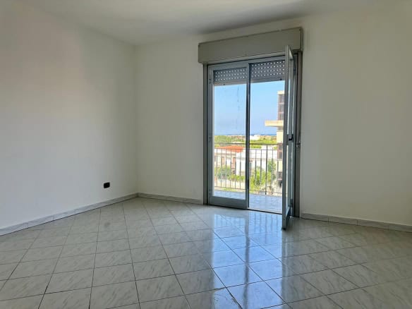 Stanza luminosa con porta finestra che dà su un balcone, ideale per appartamento in vendita in via Delle Ginestre.