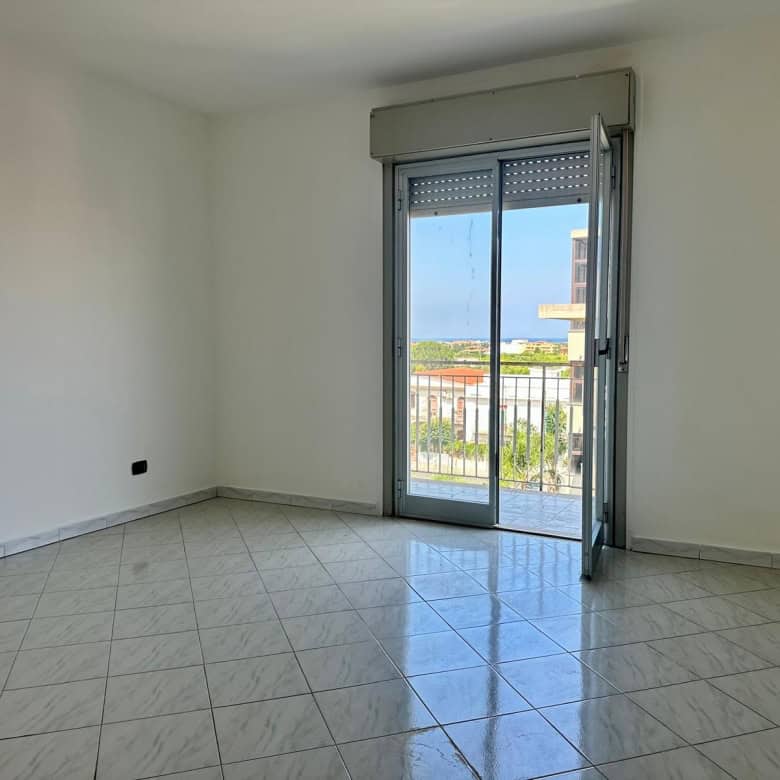 Stanza luminosa con porta finestra che dà su un balcone, ideale per appartamento in vendita in via Delle Ginestre.