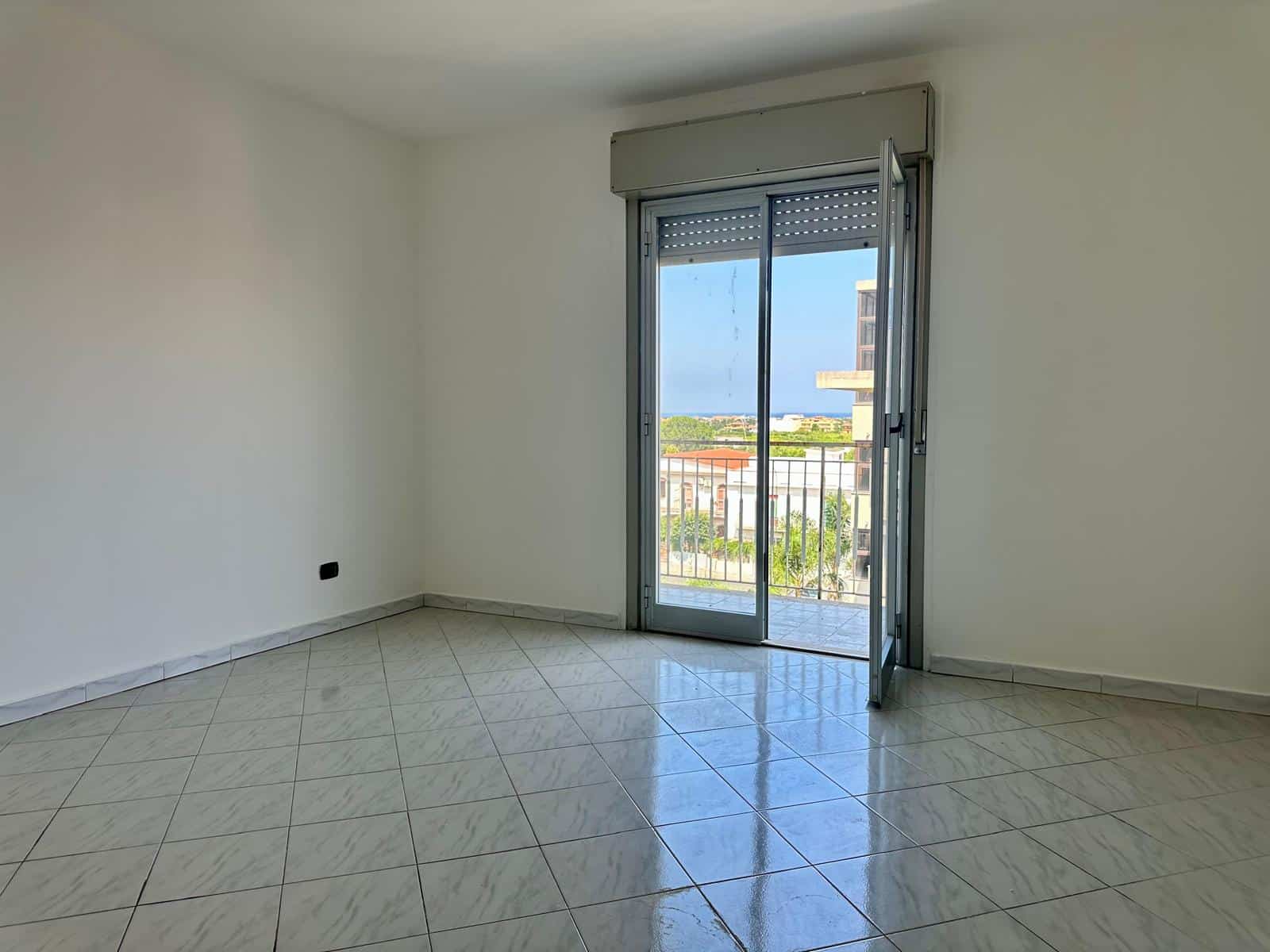 Stanza luminosa con porta finestra che dà su un balcone, ideale per appartamento in vendita in via Delle Ginestre.