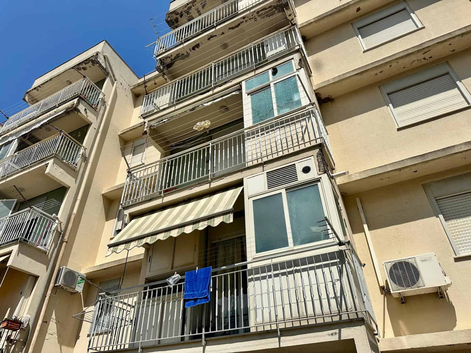 Balcone di un appartamento in vendita in via Delle Ginestre, con tende e aria condizionata.