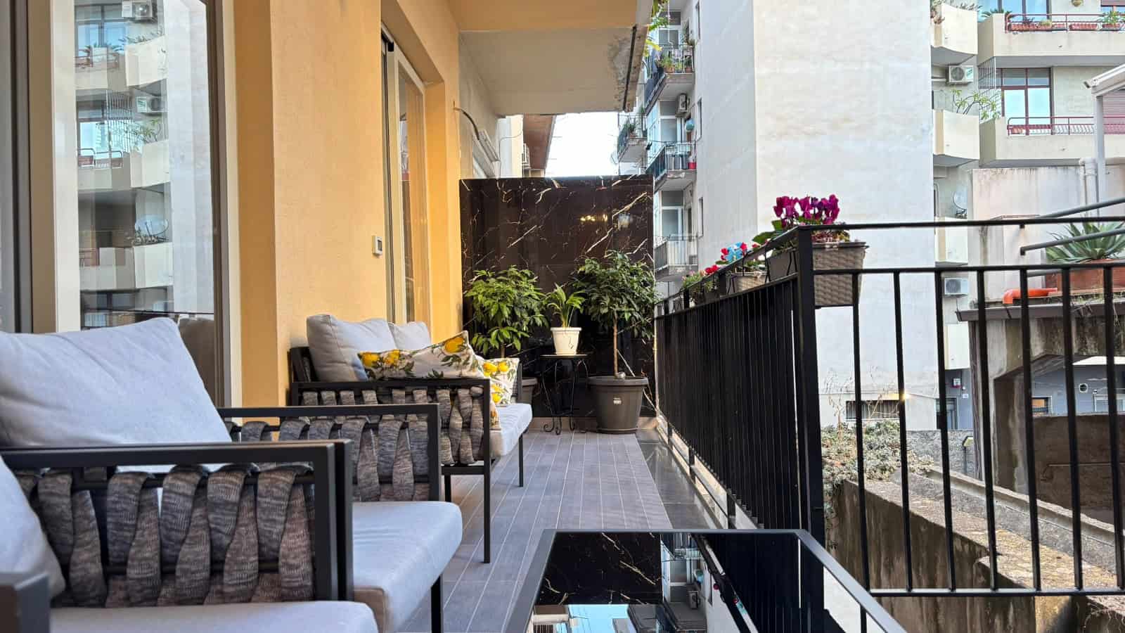Balcone di un appartamento in vendita a Milazzo con arredi moderni e piante ornamentali.