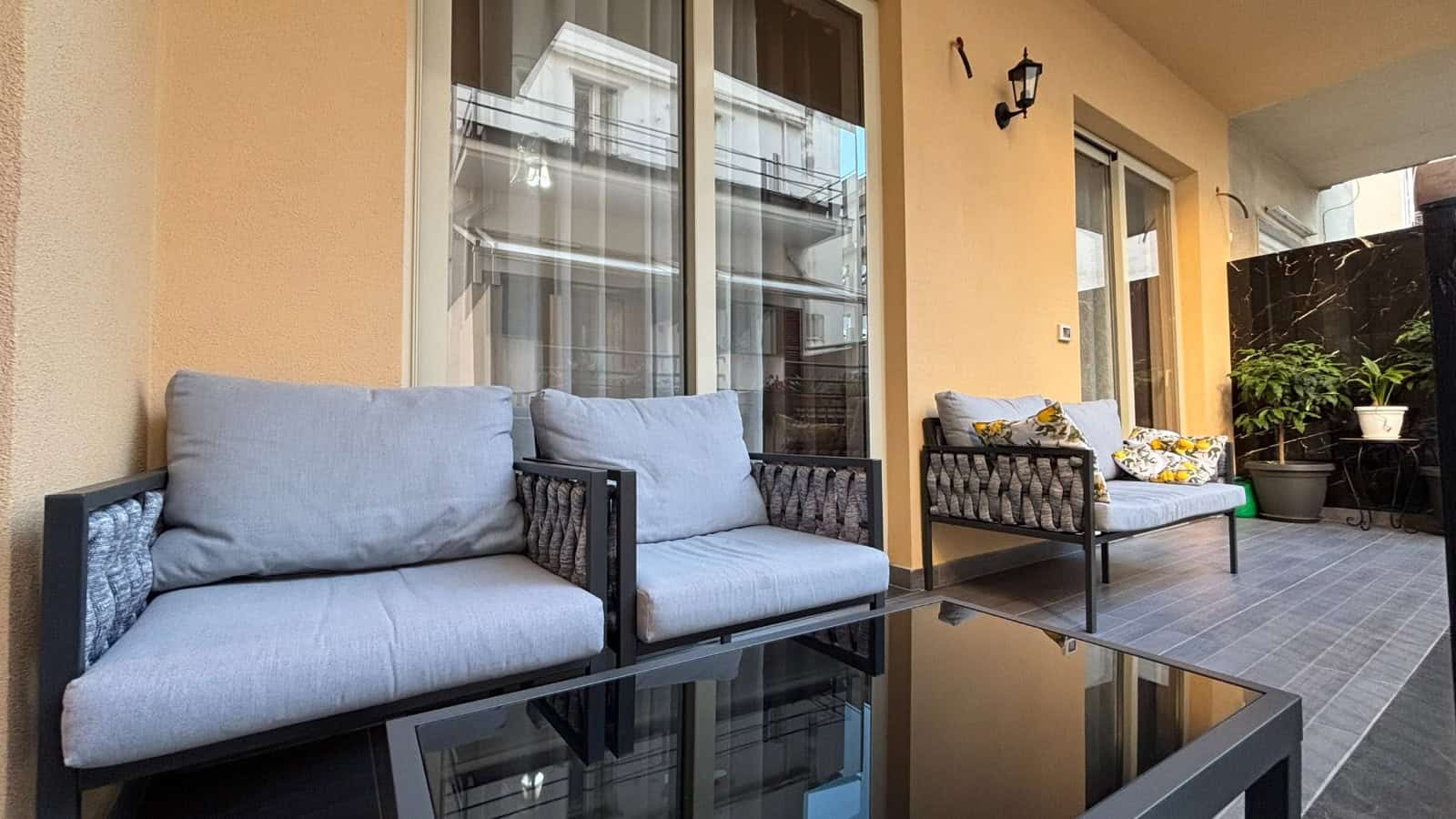 Balcone di un appartamento in vendita a Milazzo con mobili da esterno e vista sulla città.