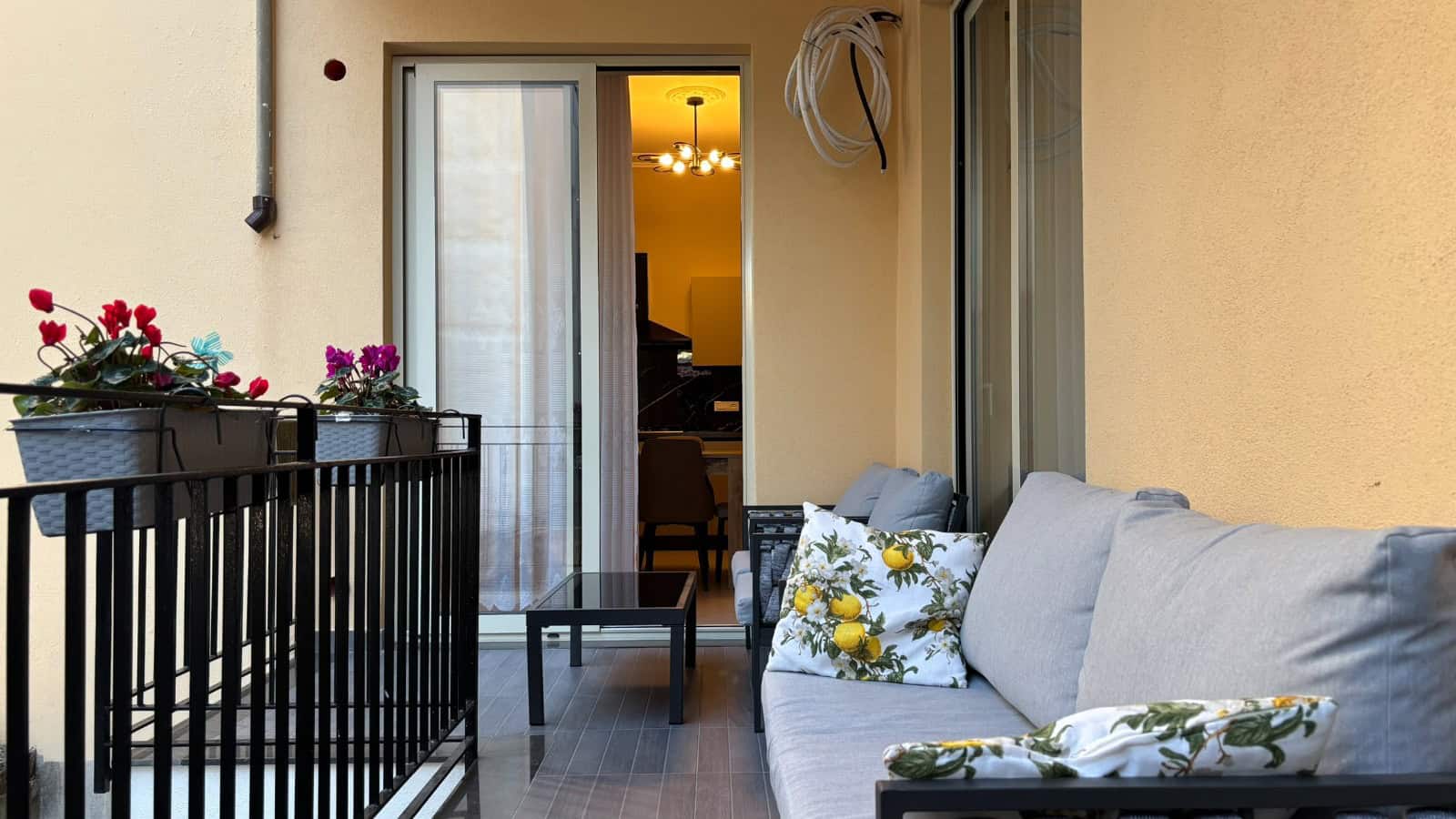 Balcone di un appartamento in vendita a Milazzo con vista sulla zona interna, arredato con divano e fiori.