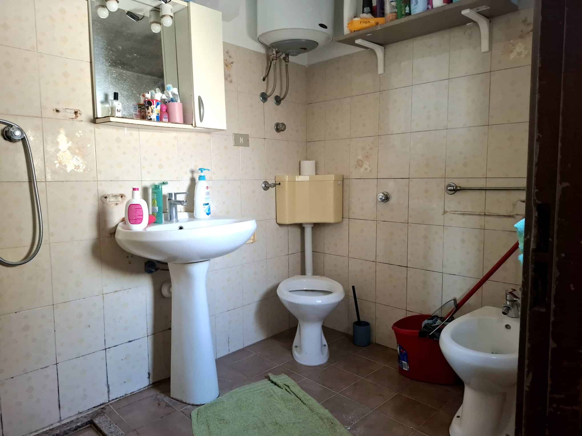 Bagno in una casa indipendente in vendita a Barcellona P.G., con lavabo, WC e bidet, pareti rivestite in piastrelle beige.