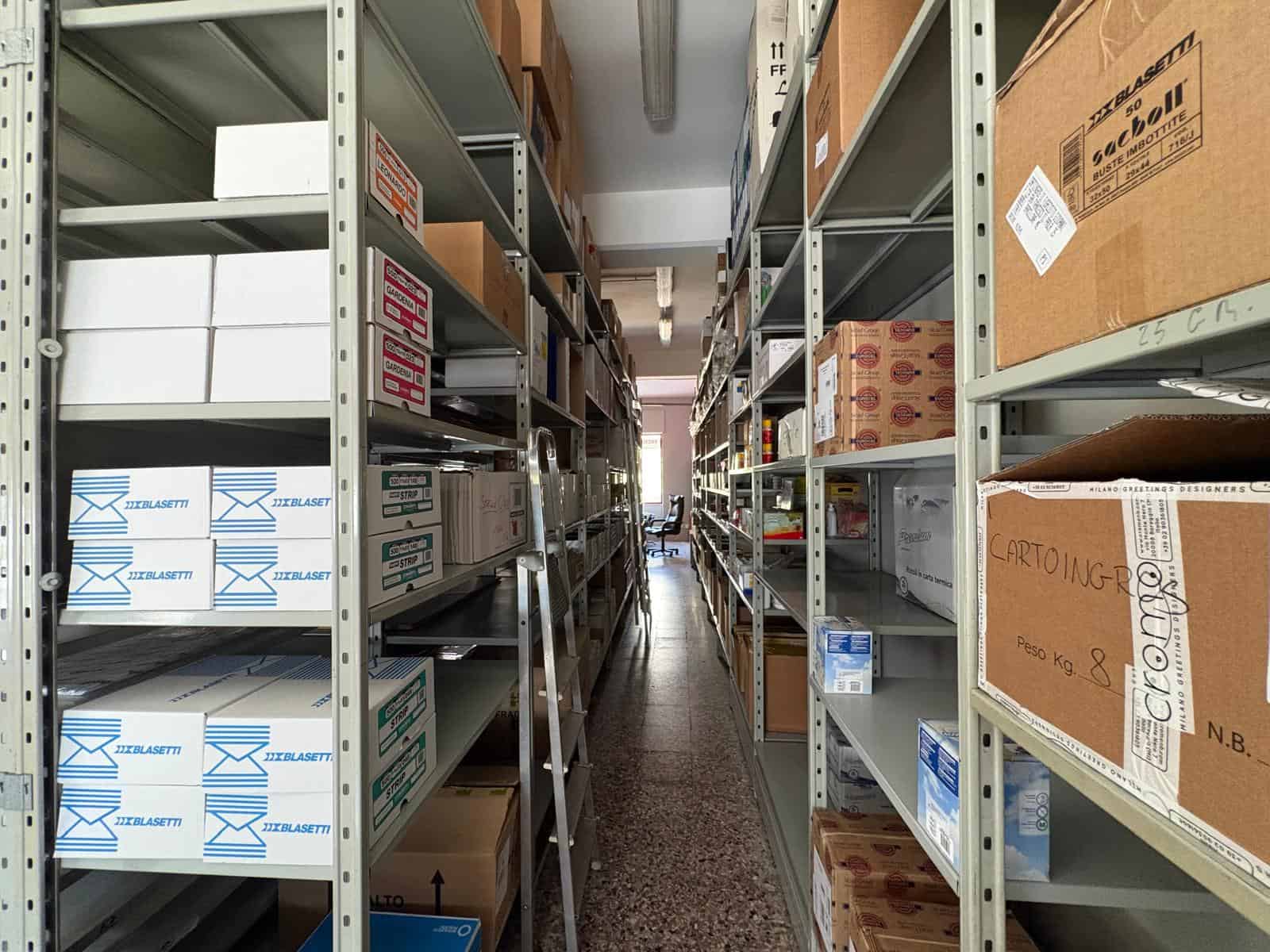 Scaffali metallici con scatole e materiali di imballaggio in un magazzino commerciale a Barcellona P.G.