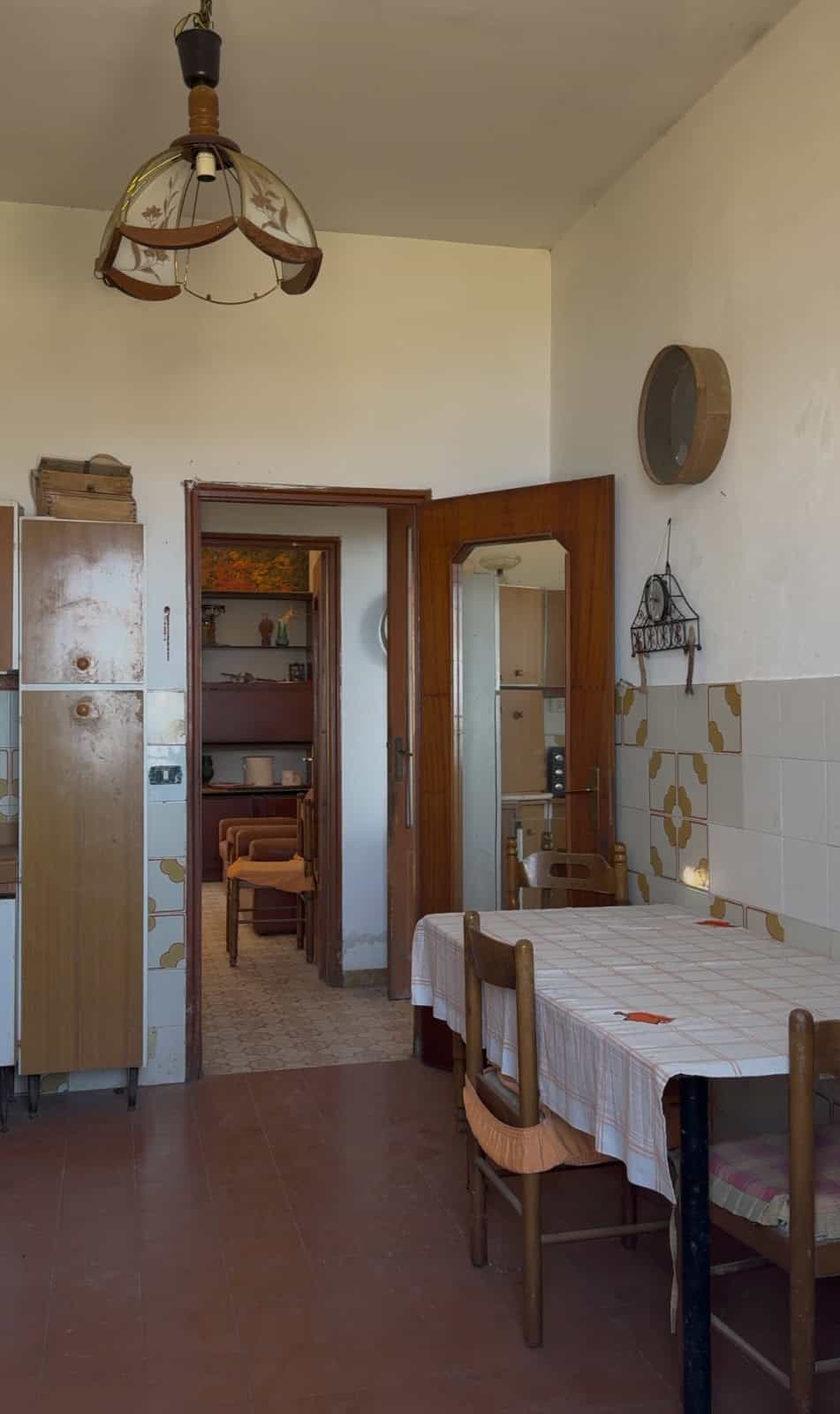 Interno di una casa a Lipari con tavolo, sedie e armadio, stile vintage e arredamento semplice.
