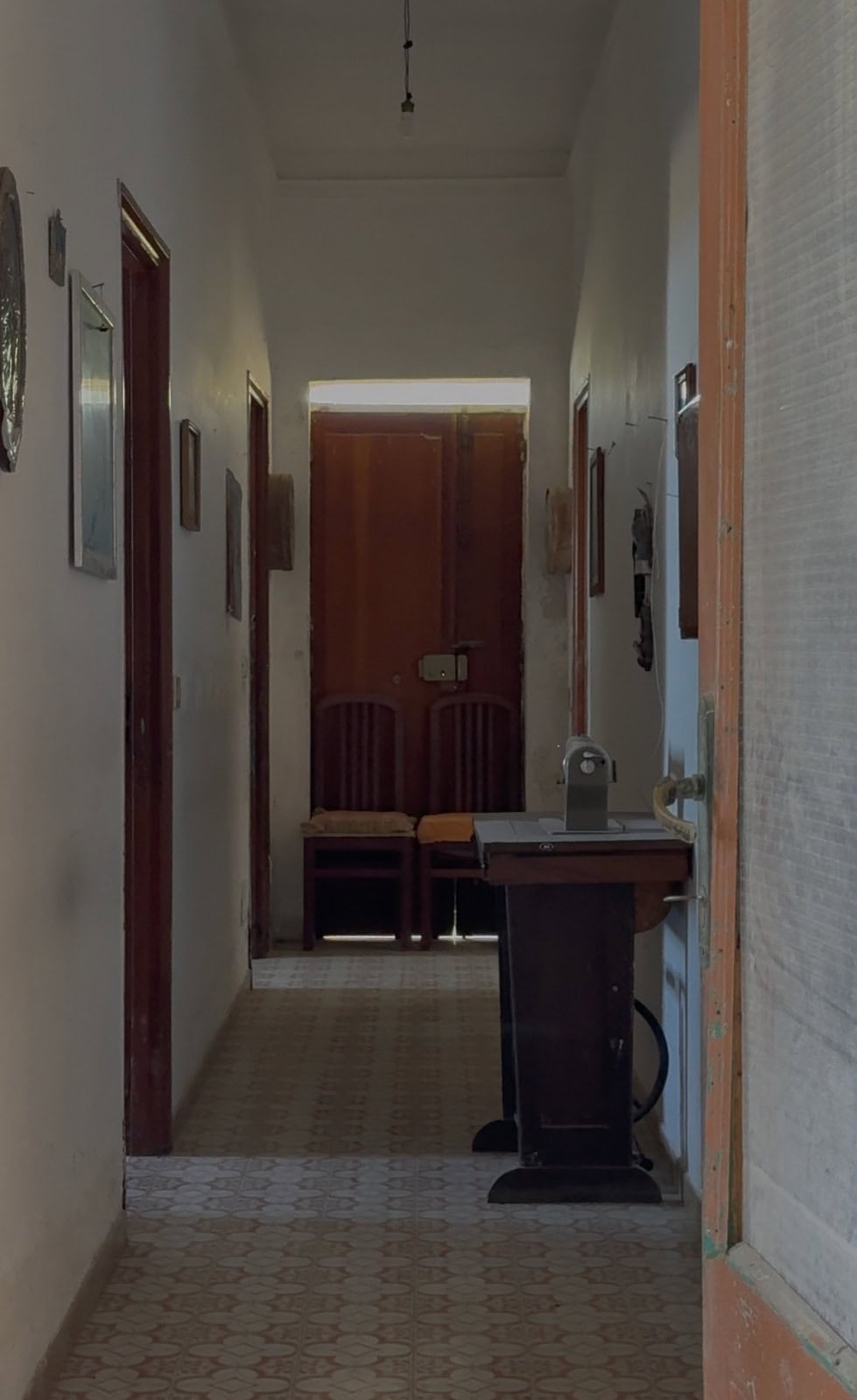 Interno di una casa a Lipari con corridoio, pareti decorate e mobili in stile classico.