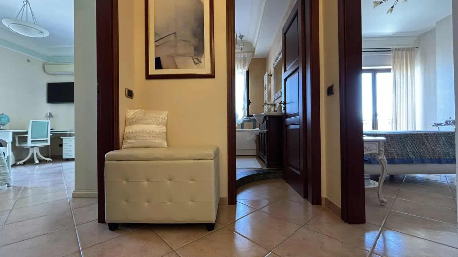 Interno di un appartamento in vendita a Milazzo, con ingresso, soggiorno e camera da letto, arredato con stile moderno e luminoso.