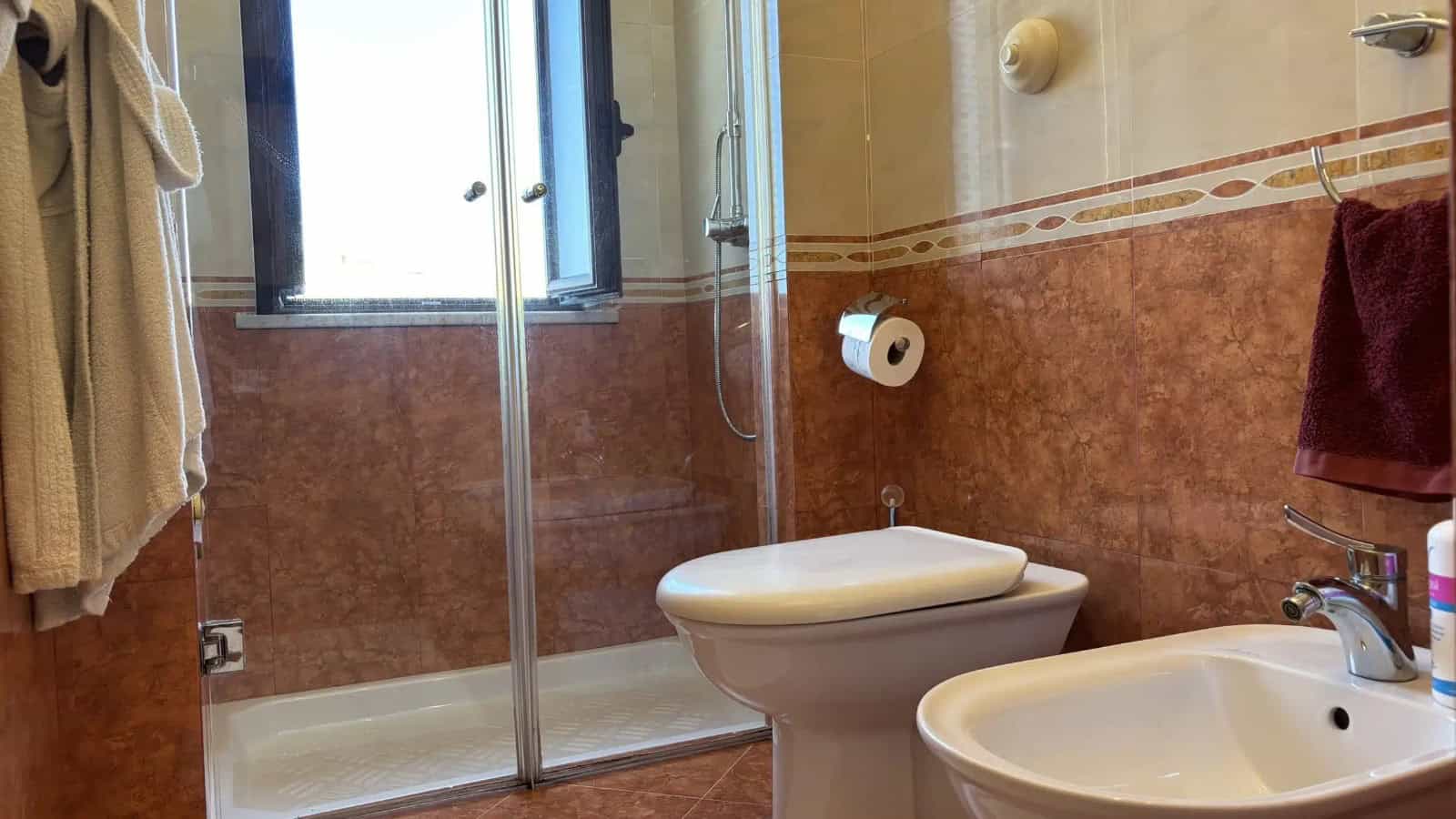 Bagno con doccia, lavabo e WC in un appartamento in vendita a Milazzo, Sicilia.