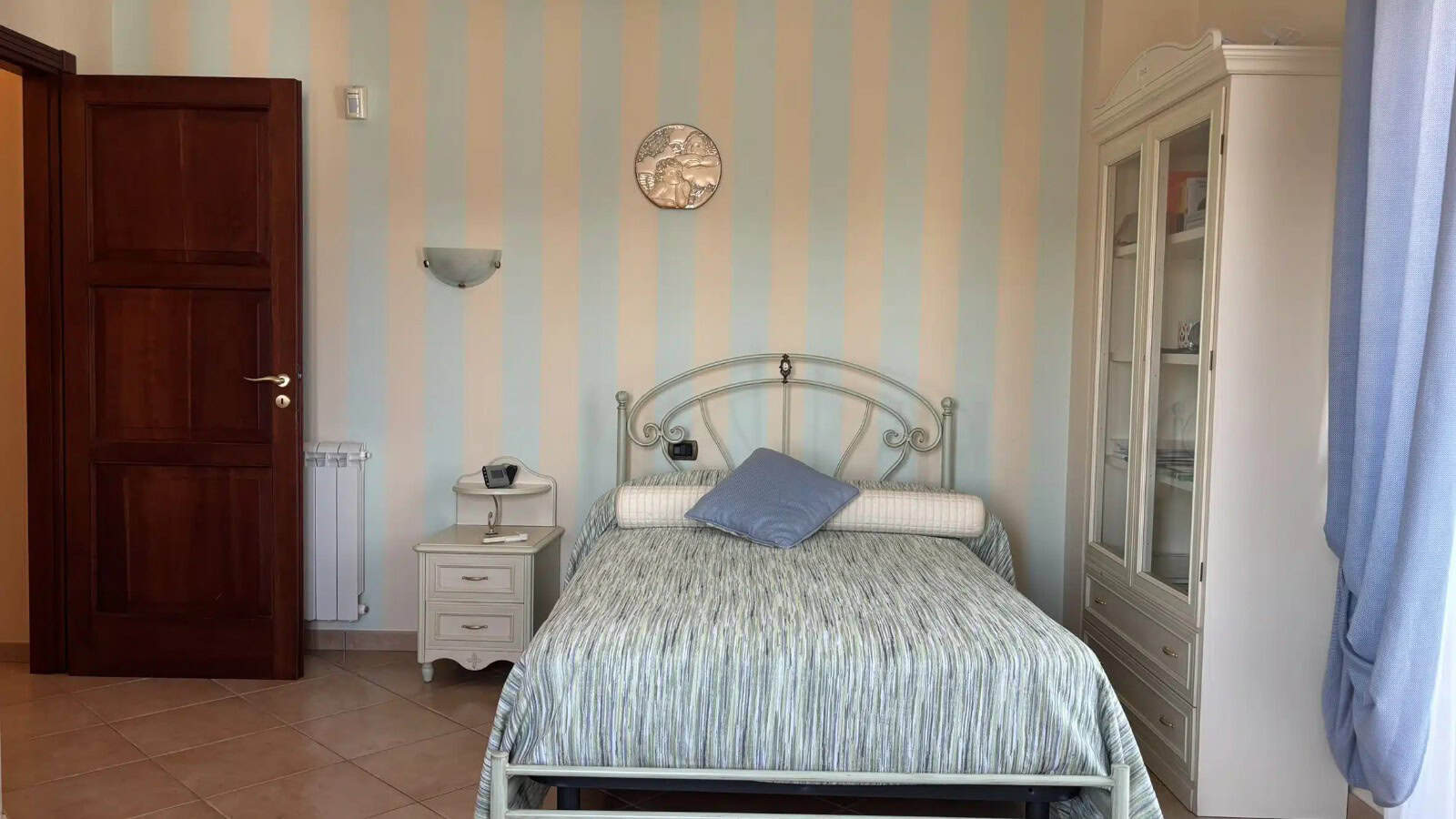 Camera che mostra una camera da letto con letto matrimoniale, armadio e decorazioni eleganti.