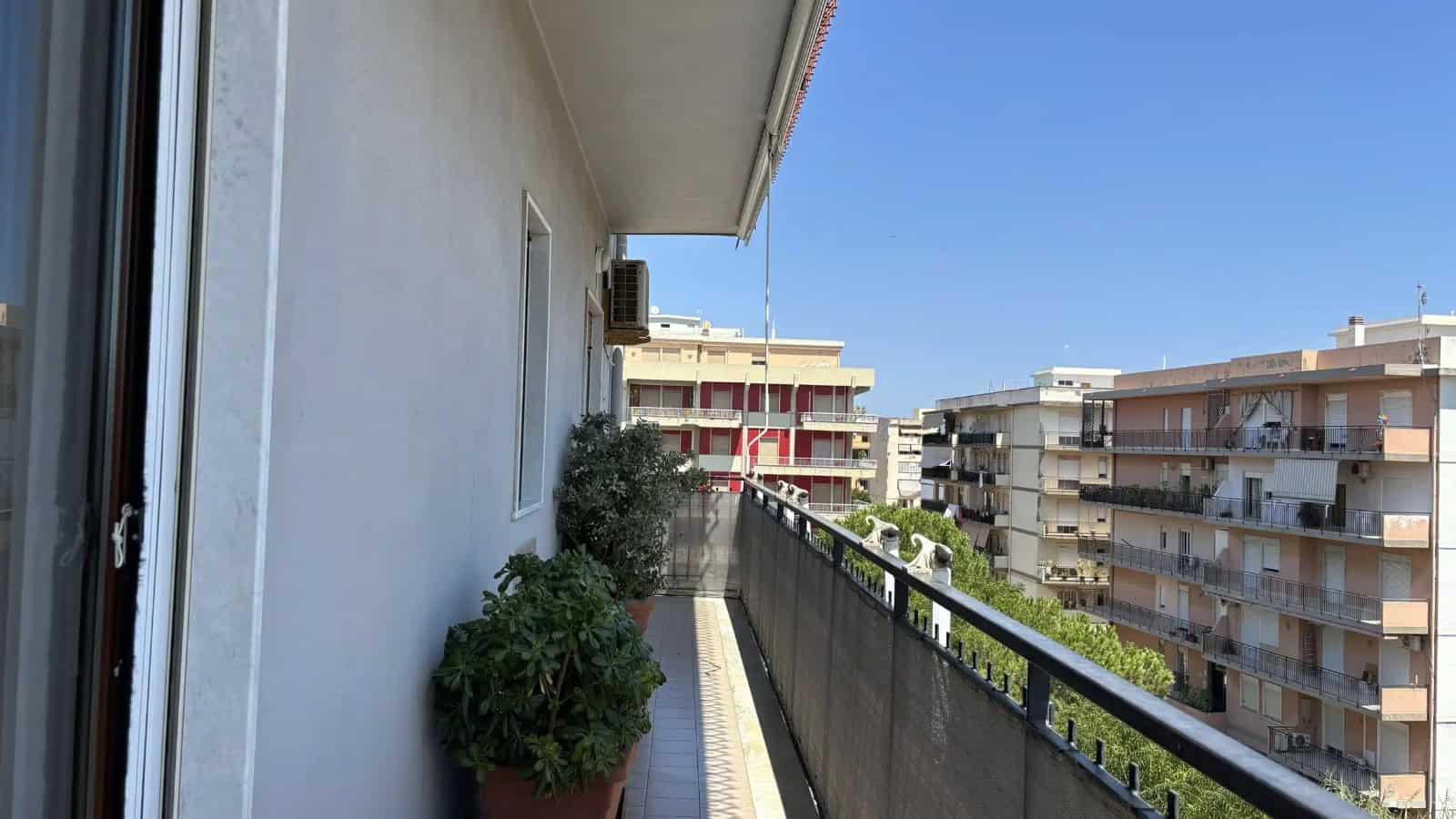 Balcone di un appartamento con piante e vista su edifici residenziali a Milazzo, ME.