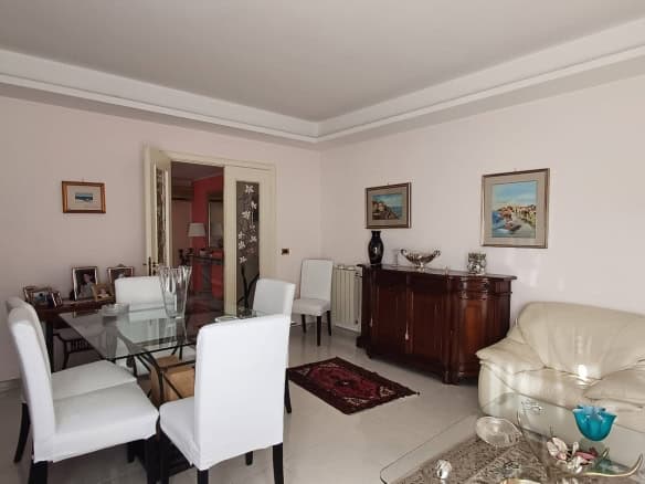 Interno di un appartamento con sala da pranzo elegante, pareti decorate e mobili classici.