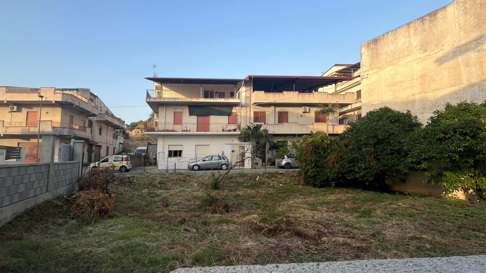 Terreno edificabile in zona residenziale con edifici moderni e spazio verde, ideale per costruzioni o investimento immobiliare a NextCasa.