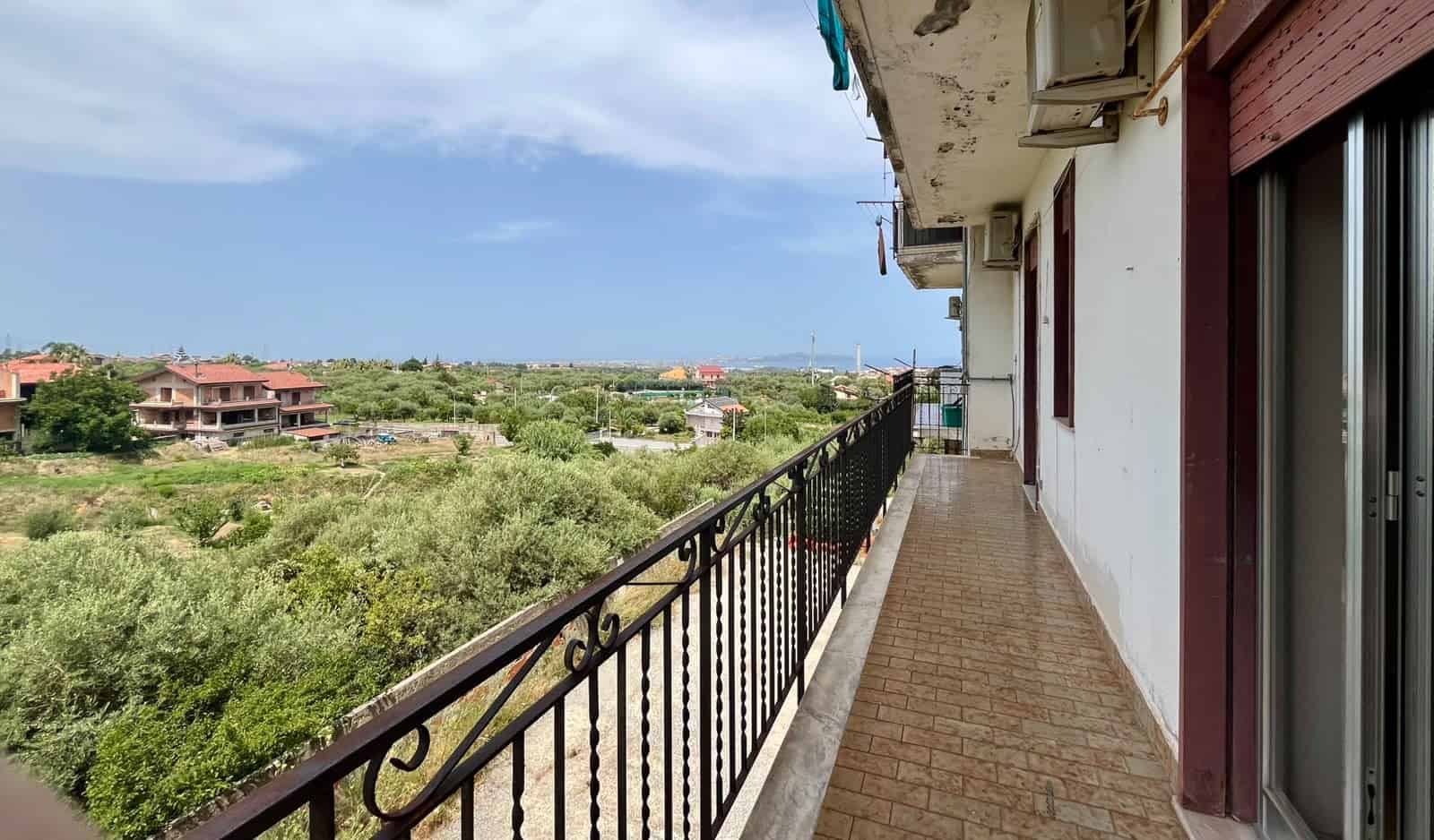 Balcone di un appartamento con vista panoramica sulla campagna di Pace del Mela, Sicilia.