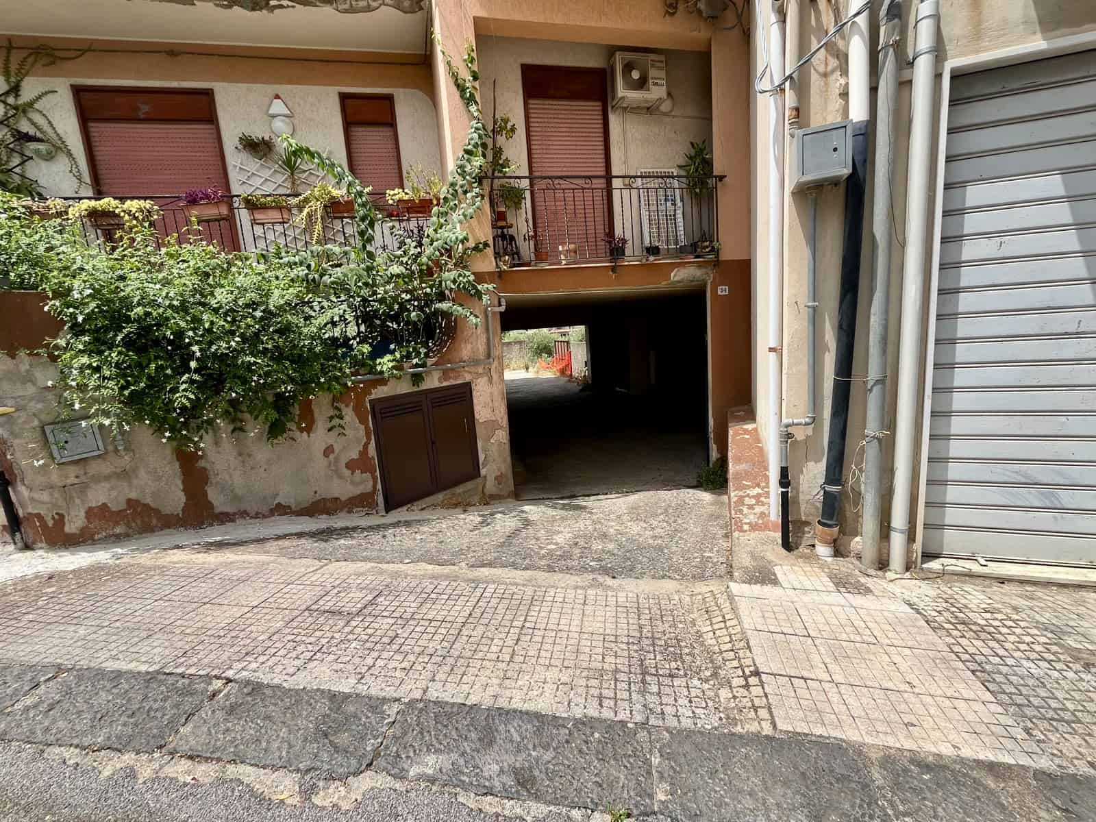 Ingresso di un appartamento in vendita in via Don Silvio Cucinotta, Pace del Mela, con garage e balcone con piante.