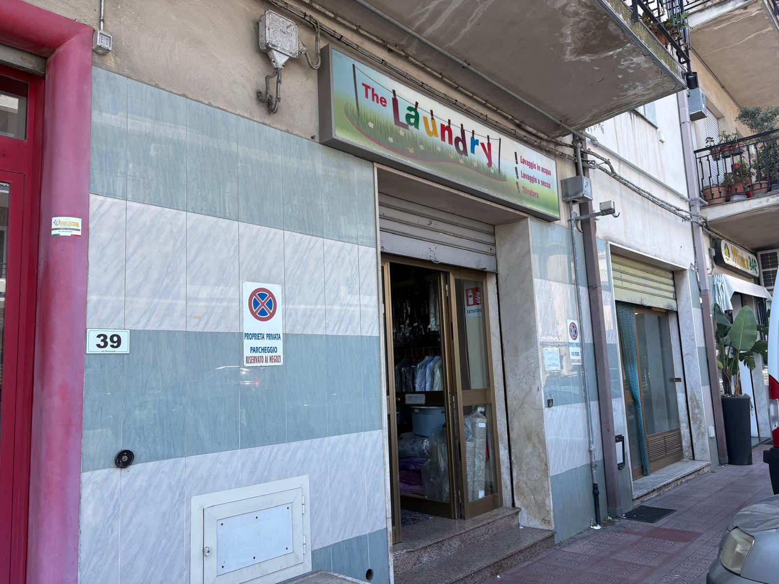 Entrata del locale commerciale in vendita in Via Nazionale 45, Giammoro, Me, con insegna 'The Laundry' e porta aperta.