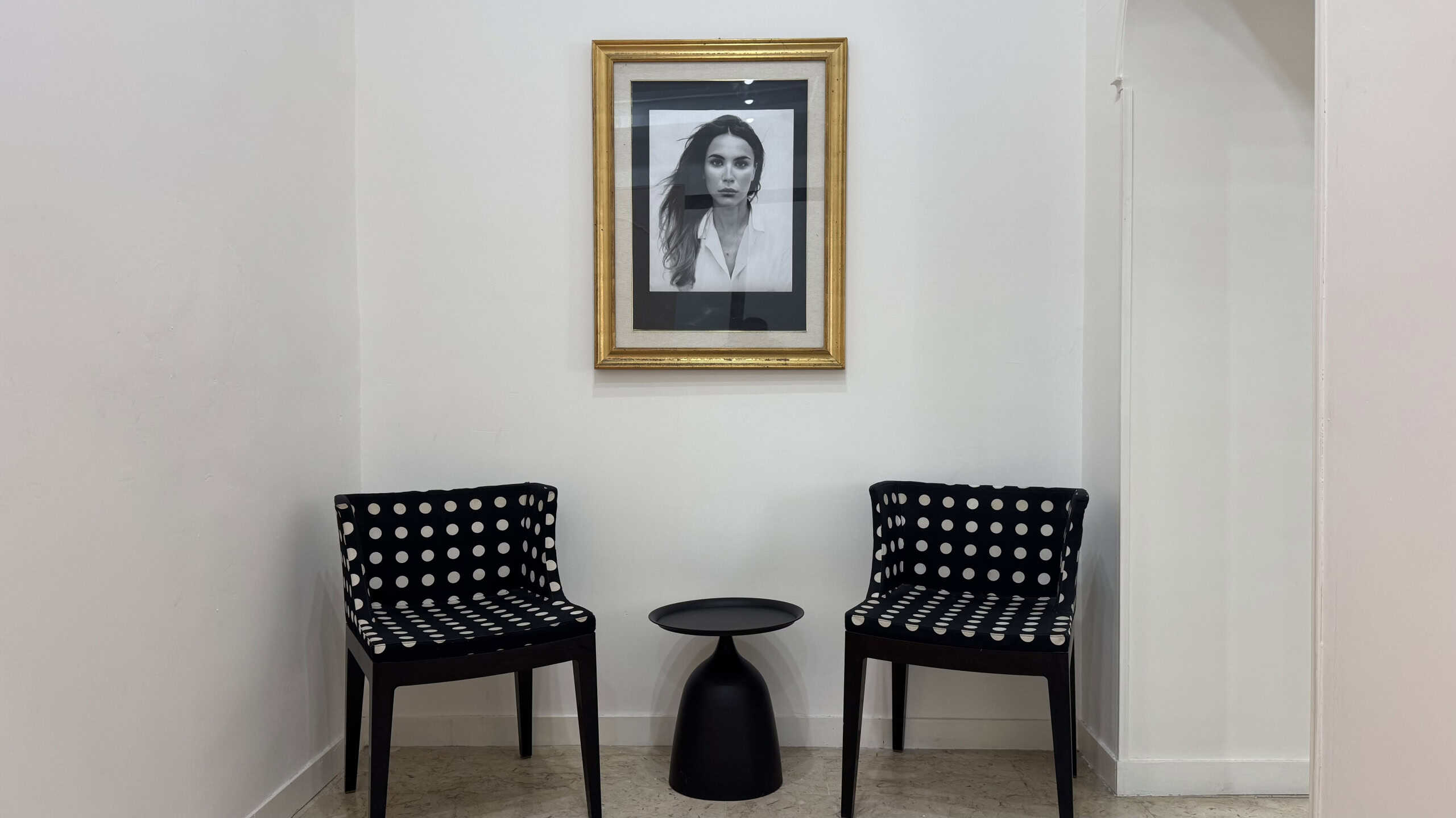 Interno di un appartamento in vendita in Via Industriale 65, Me, con due sedie nere con poltrone a pois e un quadro in bianco e nero sulla parete.