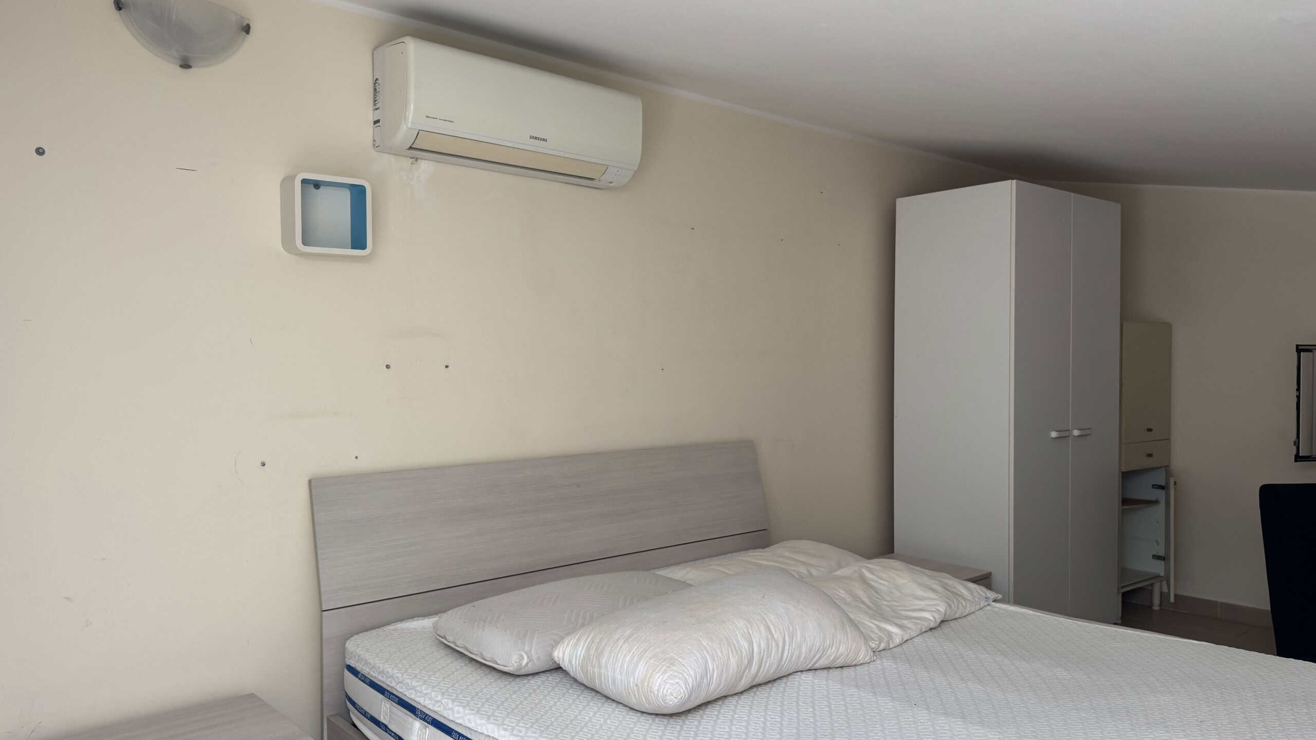 Camera da letto moderna con letto matrimoniale, armadio e aria condizionata in appartamento in affitto a Milazzo.