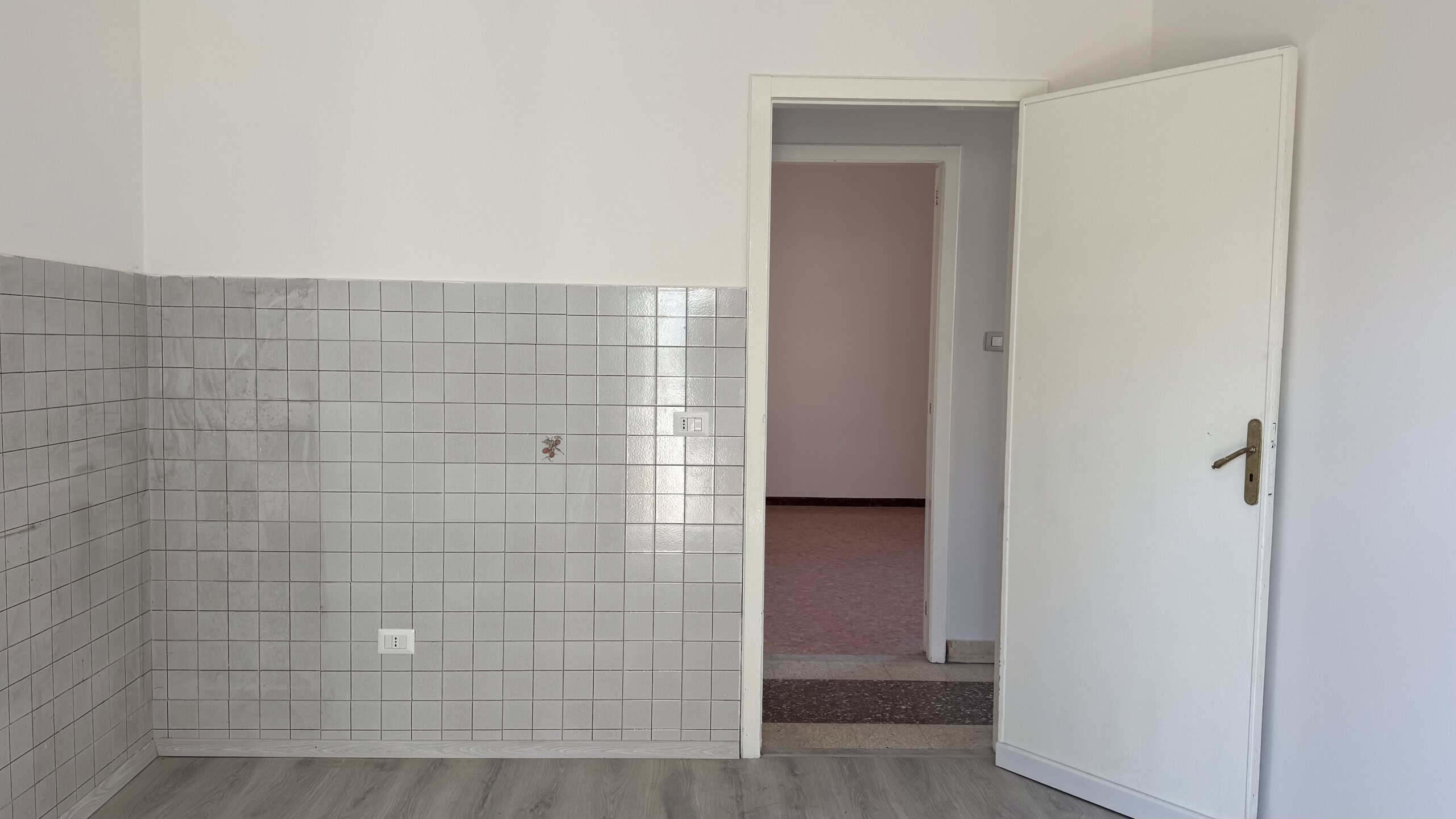 Interno di una casa semindipendente in vendita a Venetico, con pareti bianche e rivestimento in piastrelle grigie sulla metà inferiore.