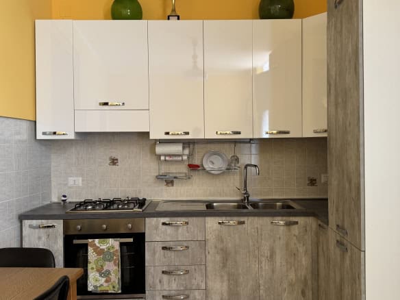 Cucina moderna con mobili bianchi e dettagli in cemento, ideale per la casa in Via Statale Sant'Antonino 273, Barcellona P.G.