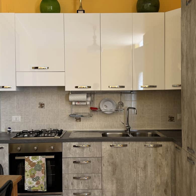 Cucina moderna con mobili bianchi e dettagli in cemento, ideale per la casa in Via Statale Sant'Antonino 273, Barcellona P.G.