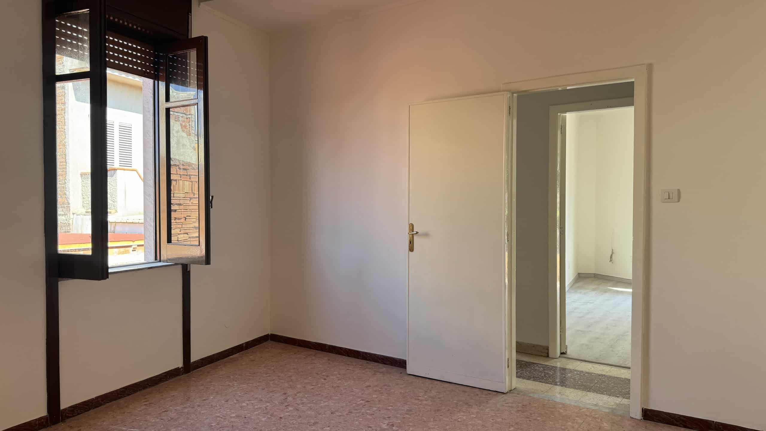 Interno di una stanza vuota con finestra e porta, in vendita a Venetico, Me.