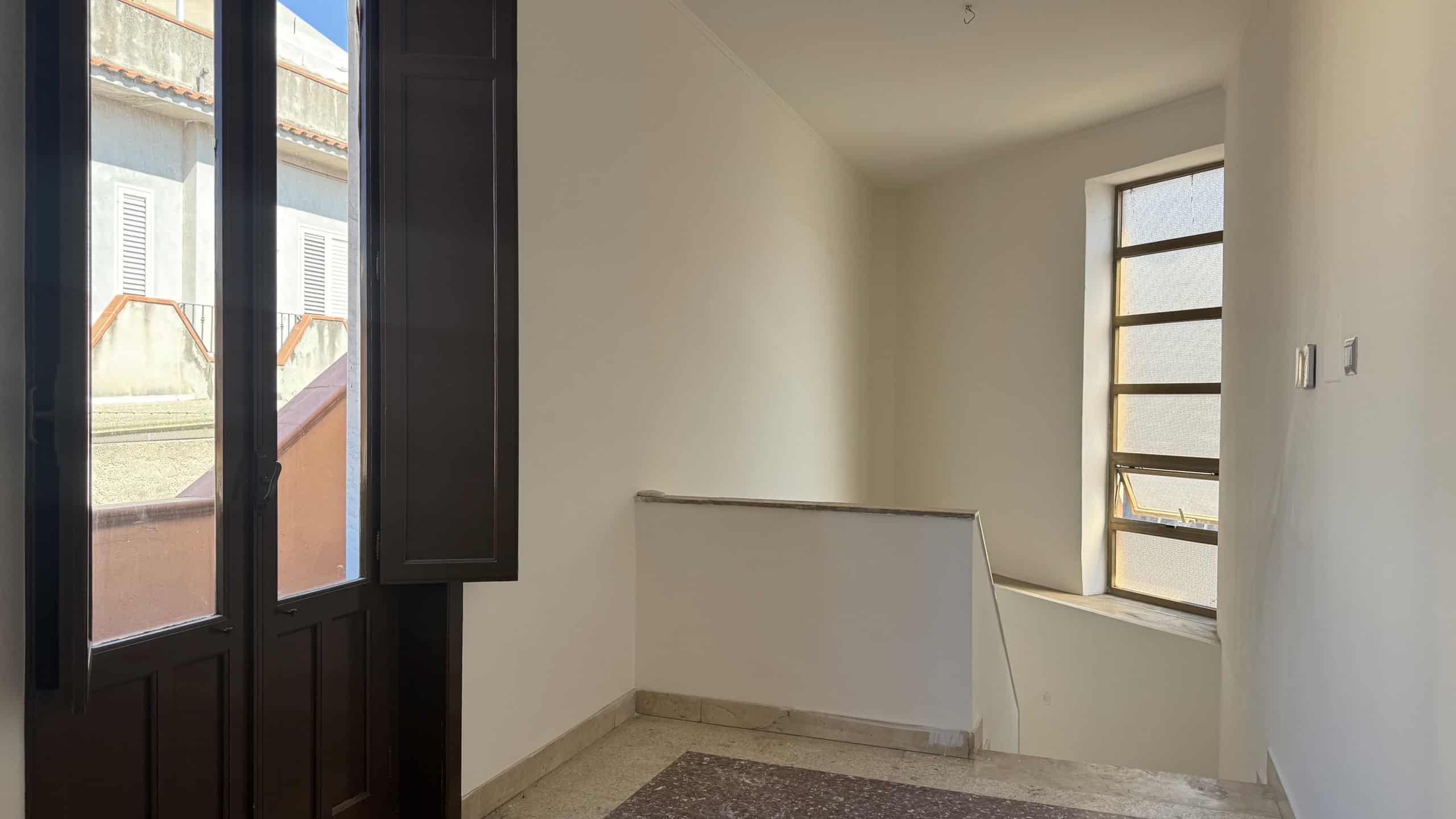 Interno di una casa semindipendente con finestra e scala, pronta per essere personalizzata.