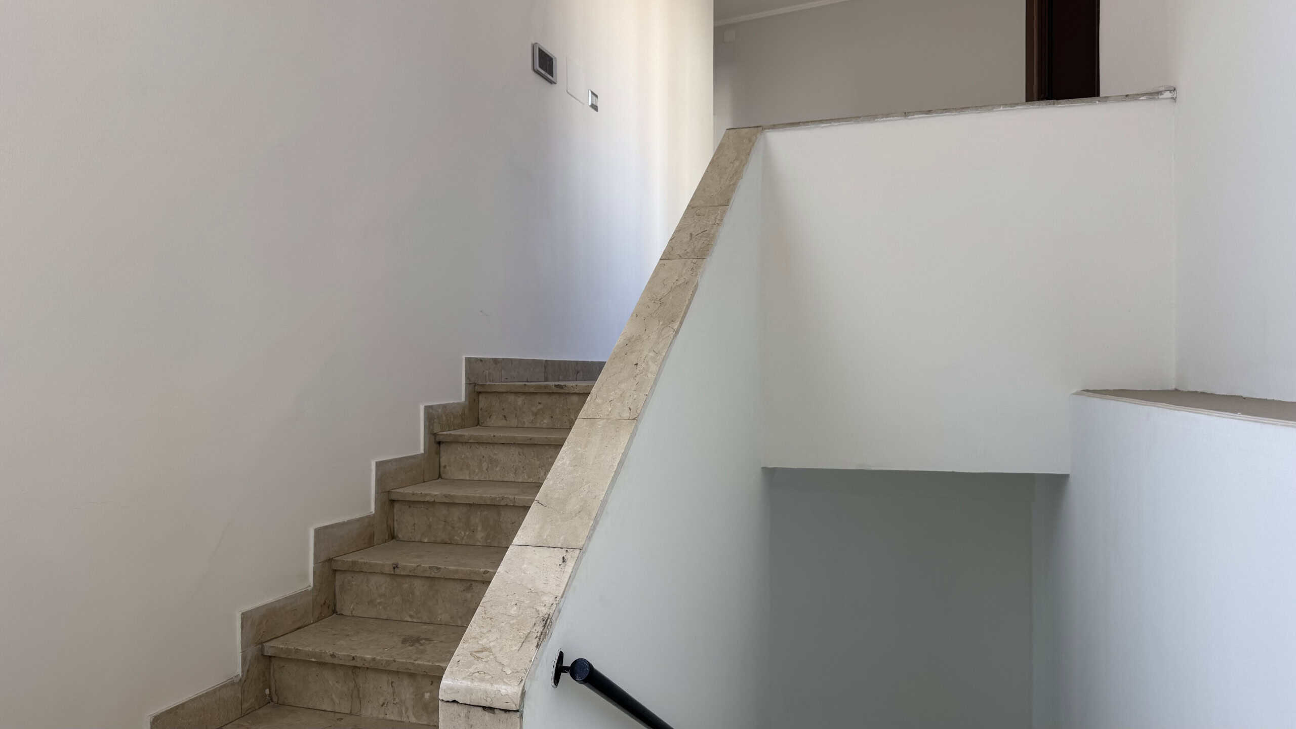 Scala interna in marmo con ringhiera nera, all'interno di una casa in vendita a Venetico, Me.