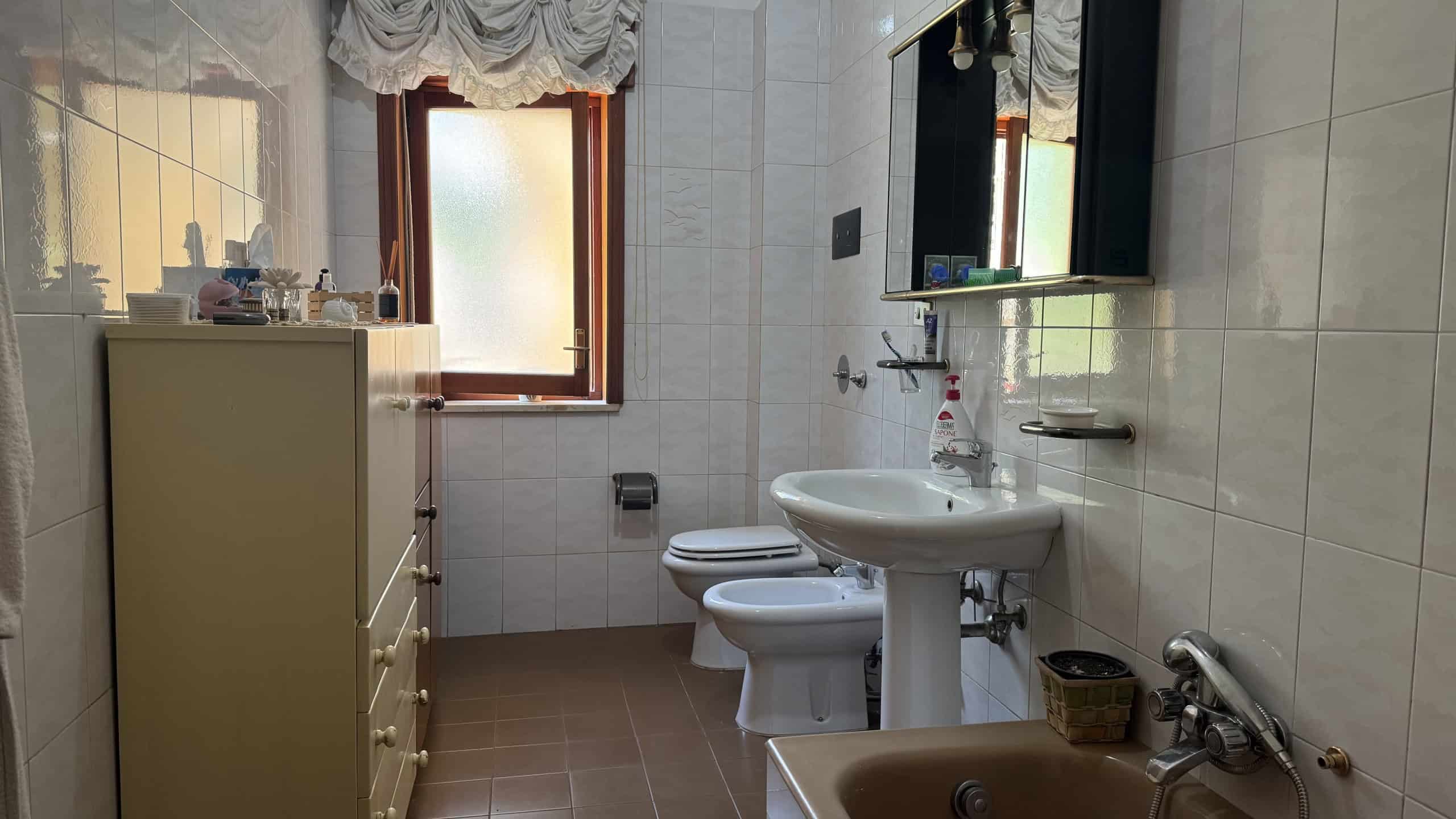 Bagno con finestra, lavabo, WC e bidet in un appartamento a Messina.
