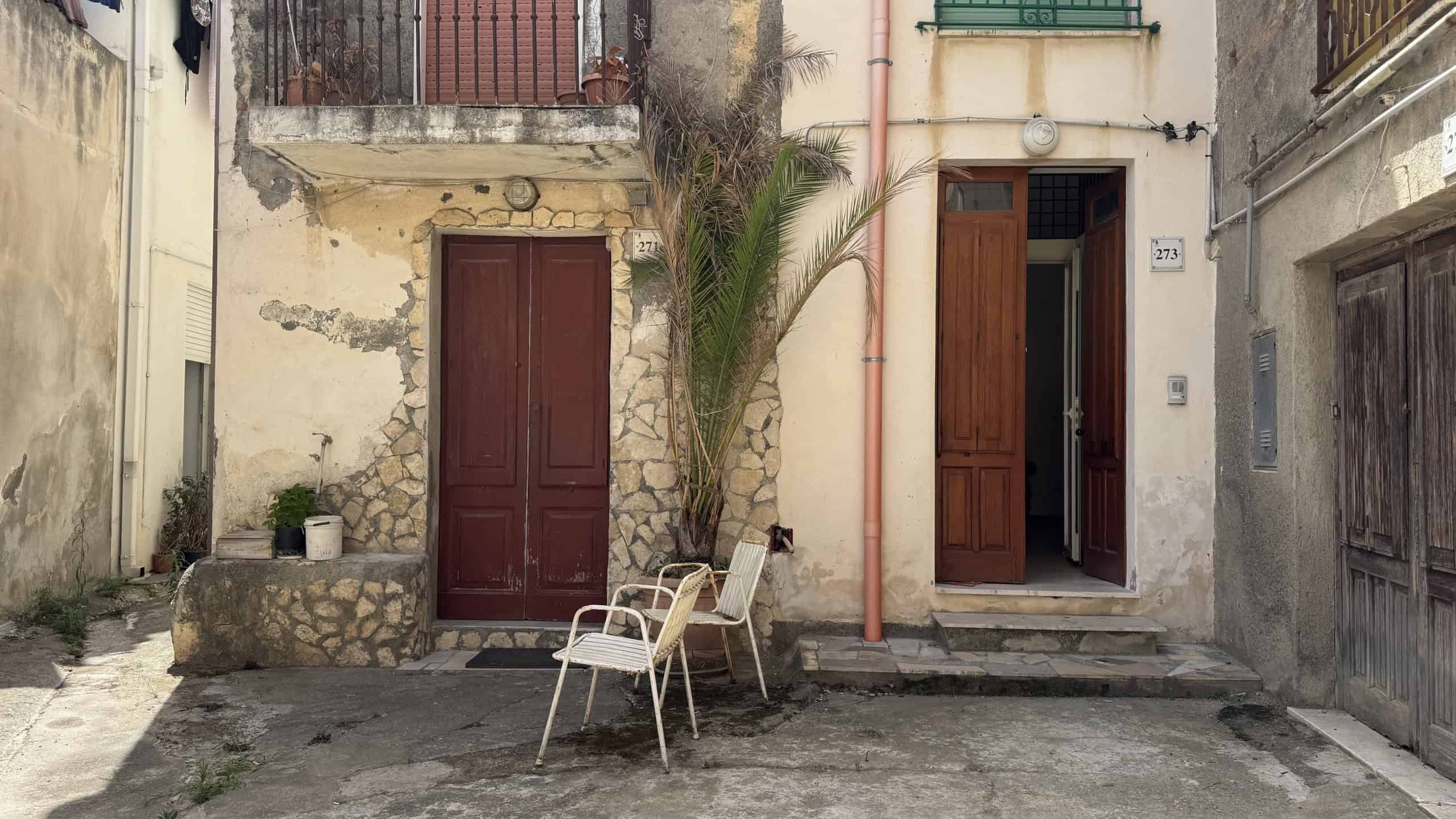 Facciata di una casa indipendente in Via Statale Sant'Antonino 273, Barcellona P.G., con porte in legno e un piccolo spazio esterno.
