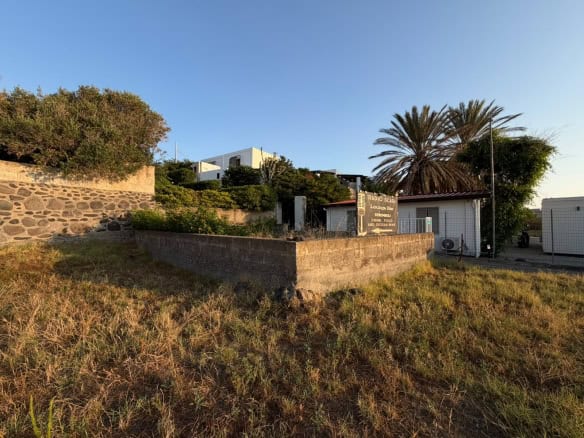 Immobile in stile moderno con giardino e palme, vista al tramonto, vicino alla costa, ideale per investimento immobiliare a NextCasa.